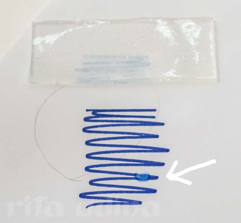 Nanorestore Gel Extra Dry (top) after placing it on top of the ink. The arrow points the drop of solvent, same in which the gel has been soaked without causing any tide-line.